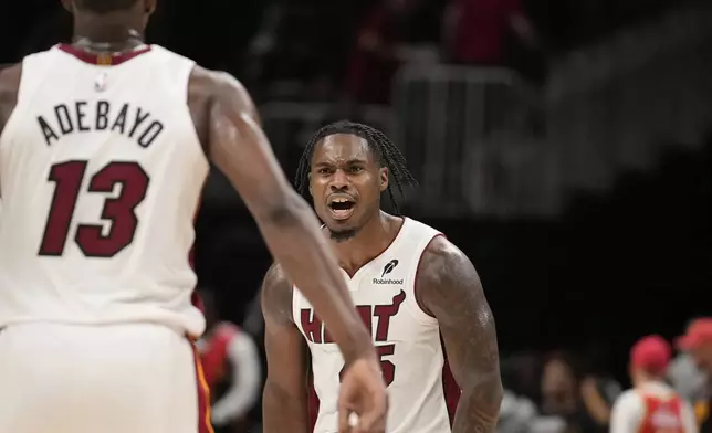 Miami Heat guard Davion Mitchell (45) celebrates with teammate Miami Heat center Bam Adebayo (13) in overtime of an NBA play-in tournament basketball game against the Atlanta Hawks, Friday, April 18, 2025, in Atlanta. (AP Photo/Brynn Anderson)