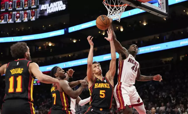 Miami Heat guard Davion Mitchell (45) and Atlanta Hawks guard Dyson Daniels (5) both go for the rebound in the second half of an NBA play-in tournament basketball game, Friday, April 18, 2025, in Atlanta. (AP Photo/Brynn Anderson)