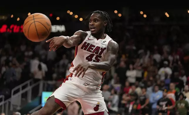 Miami Heat guard Davion Mitchell (45) passes the ball in overtime of an NBA play-in tournament basketball game against the Atlanta Hawks, Friday, April 18, 2025, in Atlanta. (AP Photo/Brynn Anderson)