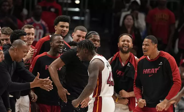 Miami Heat guard Davion Mitchell (45) cheers to the bench after scoring in overtime of an NBA play-in tournament basketball game against the Atlanta Hawks, Friday, April 18, 2025, in Atlanta. (AP Photo/Brynn Anderson)