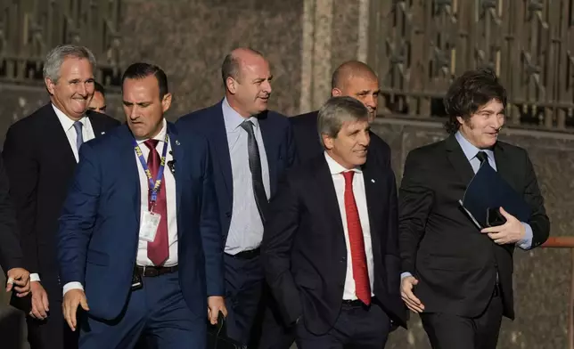 Argentina's President Javier Milei, right, and his Economy Minister Luis Caputo, second from right, enter the Economy Ministry after meeting with US Treasury Secretary Scott Bessent in Buenos Aires, Argentina, Monday, April 14, 2025. (AP Photo/Natacha Pisarenko)
