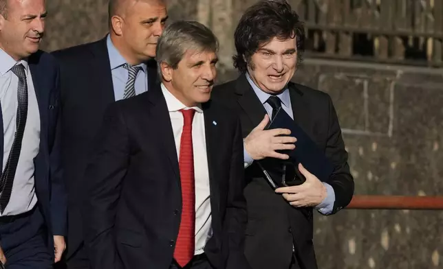 Argentine President Javier Milei, right, and his Economy Minister Luis Caputo, front, enter the Economy Ministry after meeting with U.S. Treasury Secretary Scott Bessent in Buenos Aires, Argentina, Monday, April 14, 2025. (AP Photo/Natacha Pisarenko)