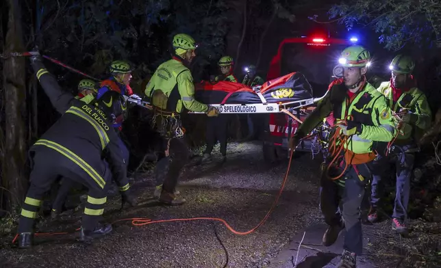 Rescuers recoup the body of one of the victims of a cable car carrying tourists south of Naples which crashed after the cable snapped, killing at least four people and injuring one in Castellamare di Stabia, near Naples, Italy, Thursday, April 17, 2025. (AP Photo/Salvatore Laporta)