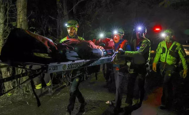 Rescuers recoup the body of one of the victims of a cable car carrying tourists south of Naples which crashed after the cable snapped, killing at least four people and injuring one in Castellamare di Stabia, near Naples, Italy, Thursday, April 17, 2025. (AP Photo/Salvatore Laporta)
