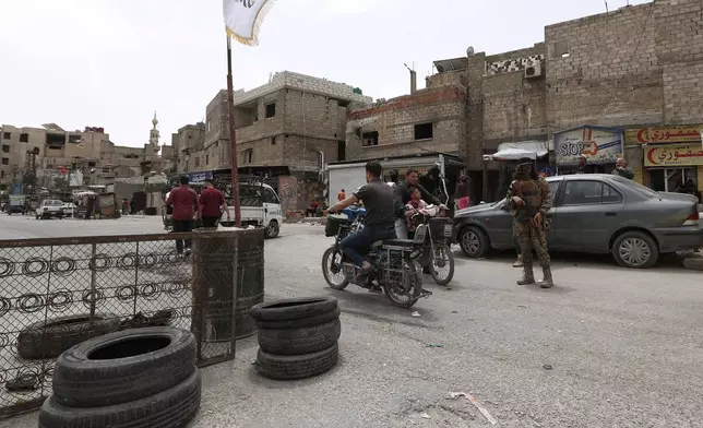 A Syrian government security forces gunman stand guards on a checkpoint at one of Jaramana suburb entrances, after clashes in the area between members of the minority Druze sect and pro-government fighters, in the southern suburb of Jaramana, Damascus, Syria, Wednesday, April 30, 2025. (AP Photo/Omar Sanadiki)
