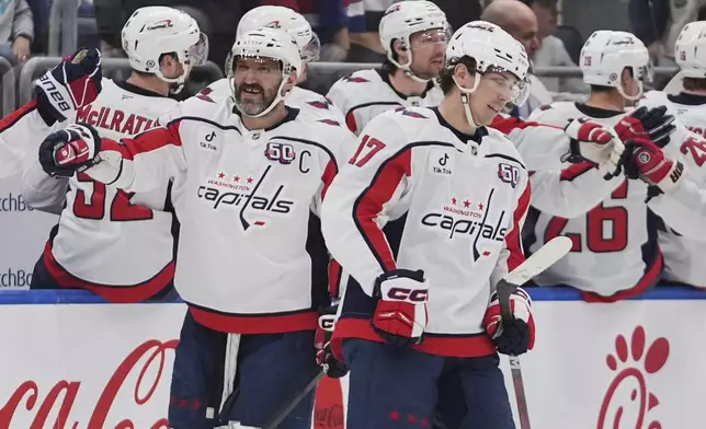 Washington Capitals' Dylan Strome, right, and Alex Ovechkin, left, celebrate with teammates after Strome scored a goal during the second period of an NHL hockey game against the New York Islanders Tuesday, April 15, 2025, in Elmont, N.Y. (AP Photo/Frank Franklin II)