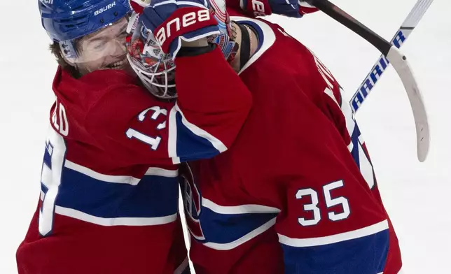 Montreal Canadiens' Cole Caufield (13) celebrates goaltender Sam Montembeault (35) after defeating the Carolina Hurricanes in NHL hockey action in Montreal on Wednesday, April 16, 2025. (Allen McInnis/The Canadian Press via AP)