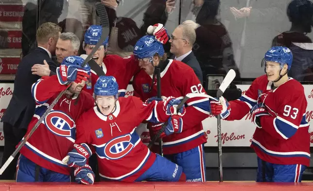 Montreal Canadiens' Alex Newhook (15), Juraj Slafkovsky (20), Cole Caufield (13), Patrik Laine (92), and Ivan Demidov (93) celebrate their win in the final minutes of play against Carolina Hurricanes during third period NHL hockey action in Montreal on Wednesday, April 16, 2025. (Christinne Muschi/The Canadian Press via AP)