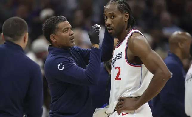 Los Angeles Clippers forward Kawhi Leonard (2) get looked at by the medics during second half of an NBA basketball game against theSacramento Kings, Friday, April 11, 2025, in Sacramento, Calif. (AP Photo/Scott Marshall)