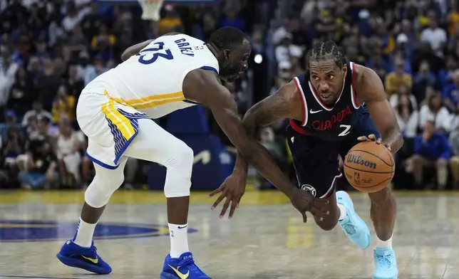 Los Angeles Clippers forward Kawhi Leonard (2) moves the ball while defended by Golden State Warriors forward Draymond Green (23) during overtime of an NBA basketball game Sunday, April 13, 2025, in San Francisco. (AP Photo/Godofredo A. Vásquez)