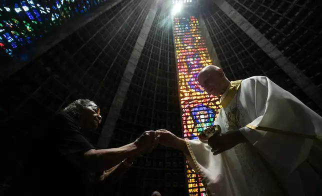 Maria Jose Florenco da Silva receives communion during Mass in honor of the late Pope Francis, following the announcement of his death, in Rio de Janeiro, Monday, April 21, 2025. (AP Photo/Bruna Prado)