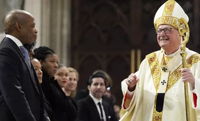 Cardinal Timothy Dolan greets New York City Mayor Eric Adams during a mass for Pope Francis at St. Patrick's Cathedral, Tuesday, April 22, 2025, in New York. (AP Photo/Julia Demaree Nikhinson)