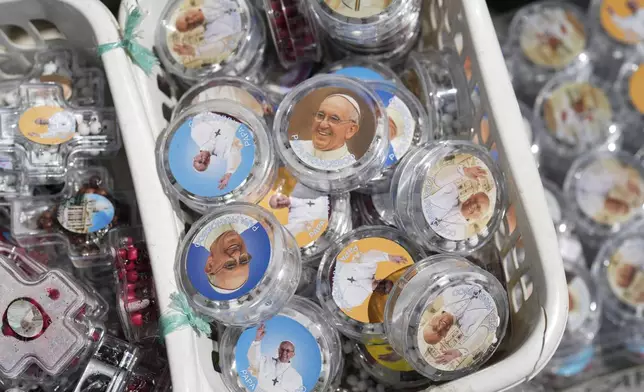 Souvenirs with images of Pope Francis are displayed next to St. Peter's Square at the Vatican, Tuesday April 22, 2025. (AP Photo/Bernat Armangue)