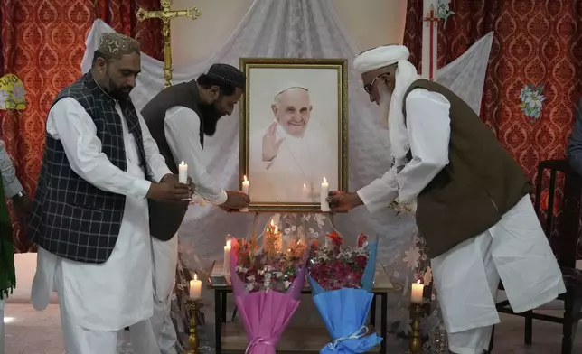 Muslim clerics place candles in front of the portrait of Pope Francis at ceremony to pay tribute to Pope at the Sacred Heart Cathedral Church, in Lahore, Pakistan Tuesday, April 22, 2025. (AP Photo/K.M. Chaudary)