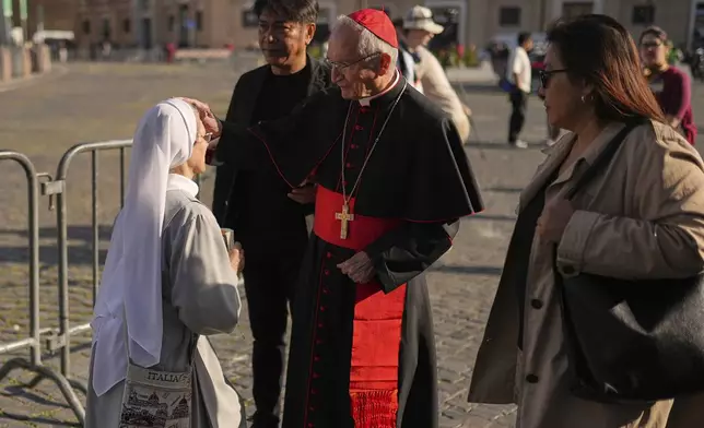 Cardinal Silvano Tomasi blesses a nun in St. Peter's Square at the Vatican, Tuesday, April 22, 2025. (AP Photo/Francisco Seco)