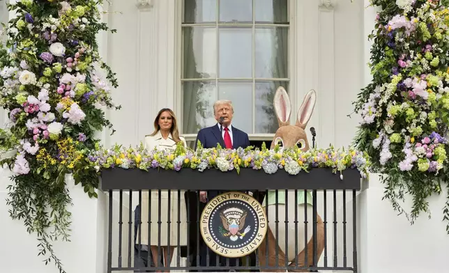President Donald Trump and first lady Melania Trump stand on the Blue Room Balcony as they participate in the White House Easter Egg Roll being held on the South Lawn of the White House, Monday, April 21, 2025, in Washington. (AP Photo/Mark Schiefelbein)