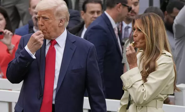 President Donald Trump and first lady Melania Trump blow whistles during the White House Easter Egg Roll on the South Lawn of the White House, Monday, April 21, 2025, in Washington. (AP Photo/Alex Brandon)