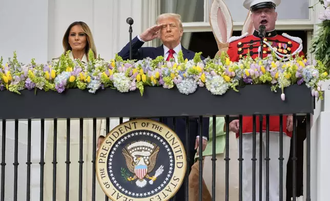 President Donald Trump and first lady Melania Trump stand on the Blue Room Balcony as they participate in the White House Easter Egg Roll being held on the South Lawn of the White House, Monday, April 21, 2025, in Washington. (AP Photo/Mark Schiefelbein)