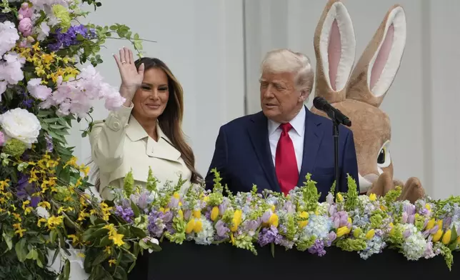 President Donald Trump and first lady Melania Trump stand on the Blue Room Balcony to participate in the White House Easter Egg Roll Monday, April 21, 2025, in Washington. (AP Photo/Alex Brandon)