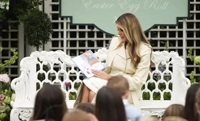First lady Melania Trump reads a book to children during the White House Easter Egg Roll at the White House, Monday, April 21, 2025, in Washington. (AP Photo/Mark Schiefelbein)
