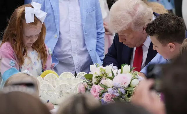 President Donald Trump sits with children during the White House Easter Egg Roll on the South Lawn of the White House, Monday, April 21, 2025, in Washington. (AP Photo/Alex Brandon)