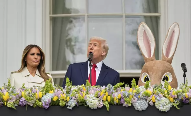 President Donald Trump and first lady Melania Trump stand on the Blue Room Balcony as they participate in the White House Easter Egg Roll being held on the South Lawn of the White House, Monday, April 21, 2025, in Washington. (AP Photo/Mark Schiefelbein)
