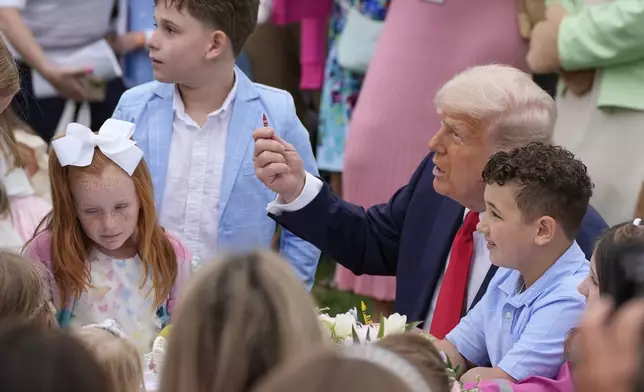 President Donald Trump sits with children during the White House Easter Egg Roll on the South Lawn of the White House, Monday, April 21, 2025, in Washington. (AP Photo/Alex Brandon)