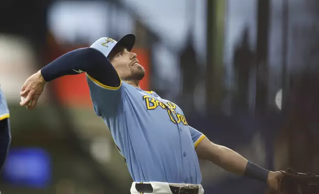 Milwaukee Brewers' Caleb Durbin throws a ball into the stands before a baseball game against the Athletics, Friday, April 18, 2025, in Milwaukee. (AP Photo/Jeffrey Phelps)
