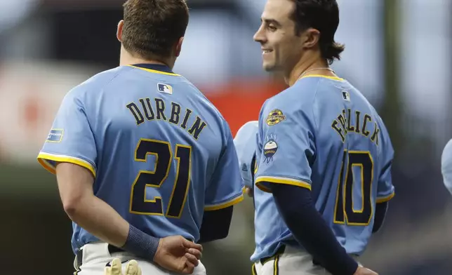 Milwaukee Brewers' Caleb Durbin (21) talks to Sal Frelick before a baseball game against the Athletics, Friday, April 18, 2025, in Milwaukee. (AP Photo/Jeffrey Phelps)
