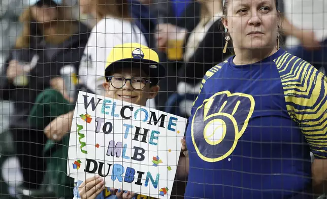 A fan holds up a sign welcoming Milwaukee Brewers' Caleb Durbin who is scheduled to make his MLB debut in a baseball game against the Athletics, Friday, April 18, 2025, in Milwaukee. (AP Photo/Jeffrey Phelps)
