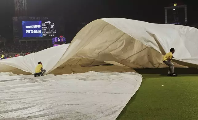 Ground staff pulls rain covers after rain interrupted the play during the Indian Premier League cricket match between Kolkata Knight Riders and Punjab Kings at Eden Gardens in Kolkata in Kolkata , India, Saturday, April 26, 2025. (AP Photo/Bikas Das)