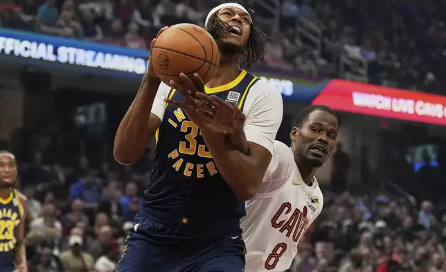 Indiana Pacers center Myles Turner (33) is fouled by Cleveland Cavaliers guard Javonte Green (8) in the first half of an NBA basketball game Sunday, April 13, 2025, in Cleveland. (AP Photo/Sue Ogrocki)