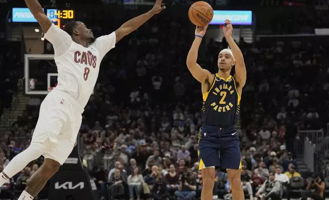 Indiana Pacers guard Andrew Nembhard (2) shoots as Cleveland Cavaliers guard Javonte Green (8) defends in the first half of an NBA basketball game Sunday, April 13, 2025, in Cleveland. (AP Photo/Sue Ogrocki)