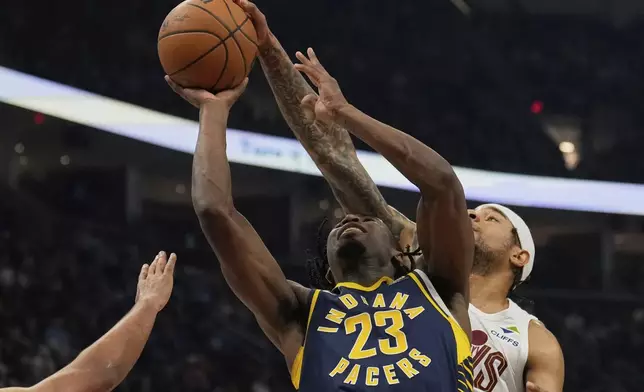 Cleveland Cavaliers forward Chuma Okeke, right, blocks a shot by Indiana Pacers forward Aaron Nesmith (23) in the first half of an NBA basketball game Sunday, April 13, 2025, in Cleveland. (AP Photo/Sue Ogrocki)