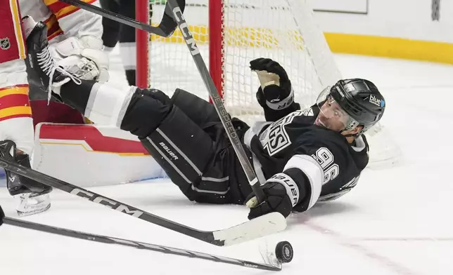 Los Angeles Kings left wing Andrei Kuzmenko reaches for the puck as he falls during the second period of an NHL hockey game against the Calgary Flames, Thursday, April 17, 2025, in Los Angeles. (AP Photo/Mark J. Terrill)