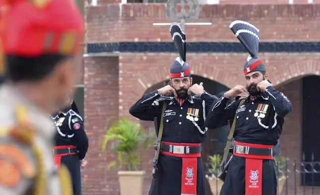 FILE- Pakistan Rangers' soldiers face Indian Border Security Force soldiers at a daily closing ceremony on the Indian side of the Attari-Wagah border, Friday, Aug. 9, 2019. (AP Photo/Prabhjot Gill, File)