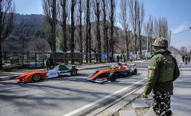FILE- A paramilitary soldier stands guard as cars drive past him during a Formula-4 race organized to boost adventure tourism in the region, in Srinagar, Indian controlled Kashmir, Sunday, March 17, 2024. (AP Photo/Mukhtar Khan, File)