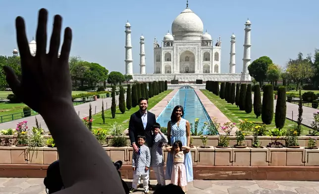 A staffer waves to U.S. Vice President JD Vance and the his family as they visit the Taj Mahal, in Agra, India, April 23, 2025. (Kenny Holston/Pool Photo via AP)