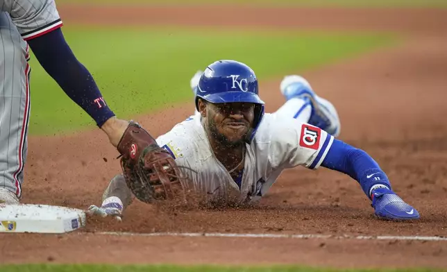 Kansas City Royals' Maikel Garcia beats the tag by Minnesota Twins first baseman Ty France as he dives back on a pickoff attempt during the third inning of a baseball game, Wednesday, April 9, 2025, in Kansas City, Mo. (AP Photo/Charlie Riedel)