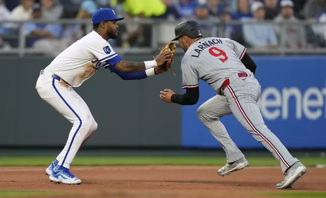 Minnesota Twins' Trevor Larnach (9) is tagged out by Kansas City Royals third baseman Maikel Garcia as he tried to advance to third on a single by Edouard Julien during the fourth inning of a baseball game, Wednesday, April 9, 2025, in Kansas City, Mo. (AP Photo/Charlie Riedel)