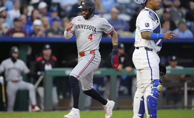 Minnesota Twins' Carlos Correa runs home to score on a single by Edouard Julien during the fourth inning of a baseball game against the Kansas City Royals, Wednesday, April 9, 2025, in Kansas City, Mo. (AP Photo/Charlie Riedel)