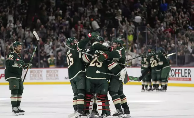 Minnesota Wild goaltender Marc-Andre Fleury (29) celebrates with teammates after the overtime win against the San Jose Sharks of an NHL hockey game, Wednesday, April 9, 2025, in St. Paul, Minn. (AP Photo/Abbie Parr)
