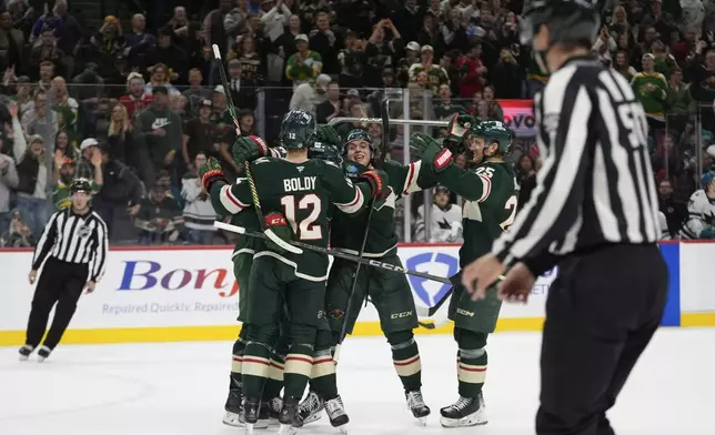 Minnesota Wild defenseman Brock Faber (7), back, center, celebrates with teammates after scoring a goal during the first period of an NHL hockey game against the San Jose Sharks, Wednesday, April 9, 2025, in St. Paul, Minn. (AP Photo/Abbie Parr)
