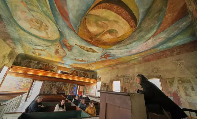 Veronique Plesch, an art professor at Colby College, gives a lecture to art teachers about the frescoes that adorn the walls and ceiling of the South Solon Meeting House, Sunday, April 6, 2025, in Solon, Maine. (AP Photo/Robert F. Bukaty)