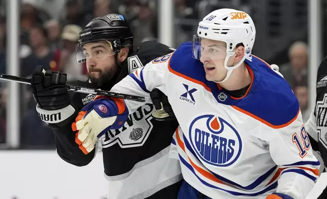 Los Angeles Kings defenseman Drew Doughty, left, and Edmonton Oilers left wing Zach Hyman scuffle in front of the goal during the first period in Game 1 of an NHL hockey first-round playoff series Monday, April 21, 2025, in Los Angeles. (AP Photo/Mark J. Terrill)