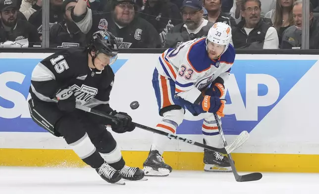 Los Angeles Kings center Alex Turcotte, left, and Edmonton Oilers left wing Viktor Arvidsson vie for the puck during the first period in Game 1 of an NHL hockey first-round playoff series Monday, April 21, 2025, in Los Angeles. (AP Photo/Mark J. Terrill)