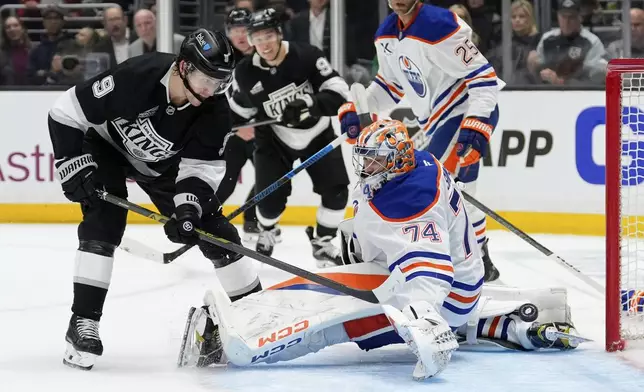 Los Angeles Kings right wing Adrian Kempe, left, scores on Edmonton Oilers goaltender Stuart Skinner during the second period in Game 1 of an NHL hockey first-round playoff series Monday, April 21, 2025, in Los Angeles. (AP Photo/Mark J. Terrill)