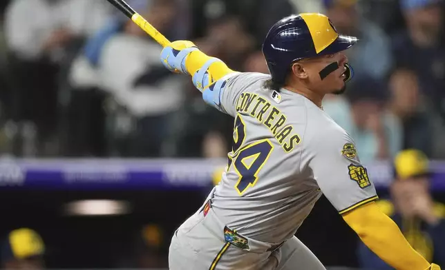 Milwaukee Brewers' William Contreras follows the flight of his solo home run off Colorado Rockies relief pitcher Jimmy Herget in the seventh inning of a baseball game Tuesday, April 8, 2025, in Denver. (AP Photo/David Zalubowski)