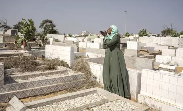 Ndeye Lam sends a prayer at the foot of her daughter Mariama's grave in Dakar, Senegal, Saturday, Jan. 11, 2025. (AP Photo/Annika Hammerschlag)
