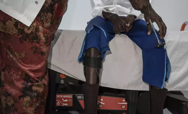 Neurology student Henriette Dieng examines Abdou Diop, a patient with genetic neuropathy at Pedro Rodriguez's clinic in Dakar, Senegal, Friday, Jan. 10, 2025. (AP Photo/Annika Hammerschlag)